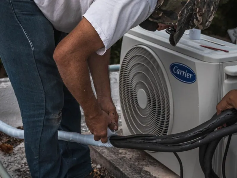 Técnico instalando las cañerías de un equipo de aire acondicionado split